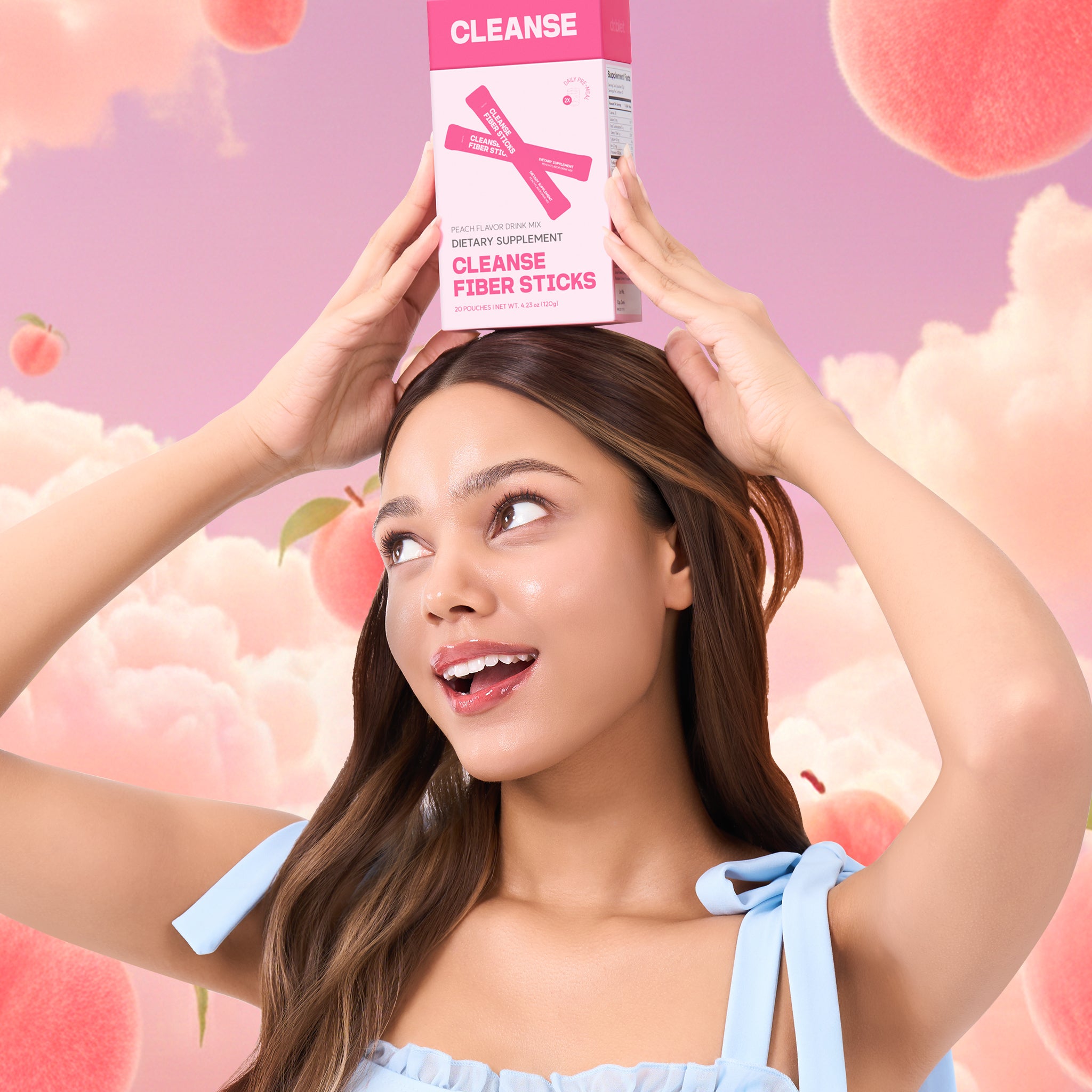 Woman holding a box of 'Cleanse' fiber sticks against a pink background with peach illustrations.
